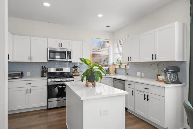 a kitchen with appliances a sink and cabinets
