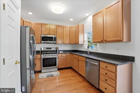 a kitchen with stainless steel appliances granite countertop a stove a sink and a refrigerator