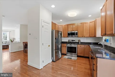 a large kitchen with stainless steel appliances granite countertop a stove a sink and a refrigerator