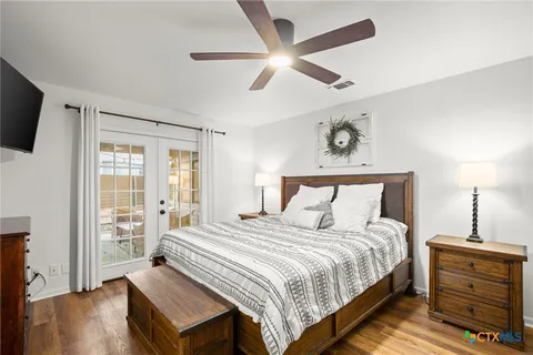 a bedroom with a bed and a flat tv screen on dresser