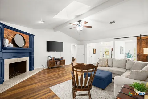 a living room with furniture a fireplace and a flat screen tv