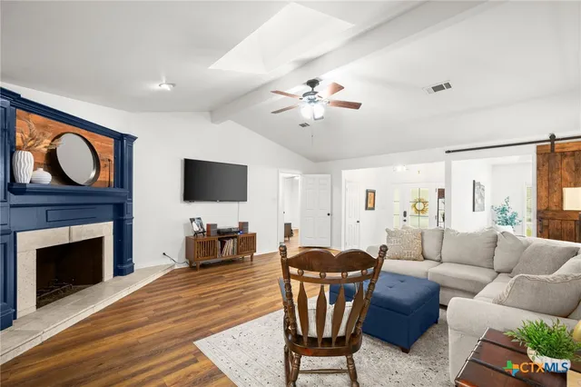 a living room with furniture a fireplace and a flat screen tv