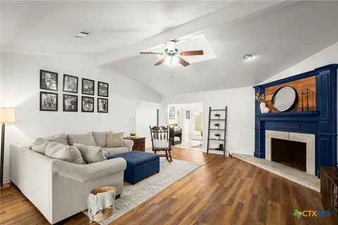 a living room with furniture a fireplace and a flat screen tv