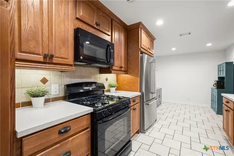 a kitchen with granite countertop a stove and a microwave