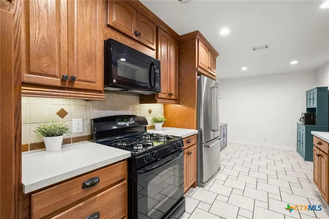 a kitchen with granite countertop a stove and a microwave