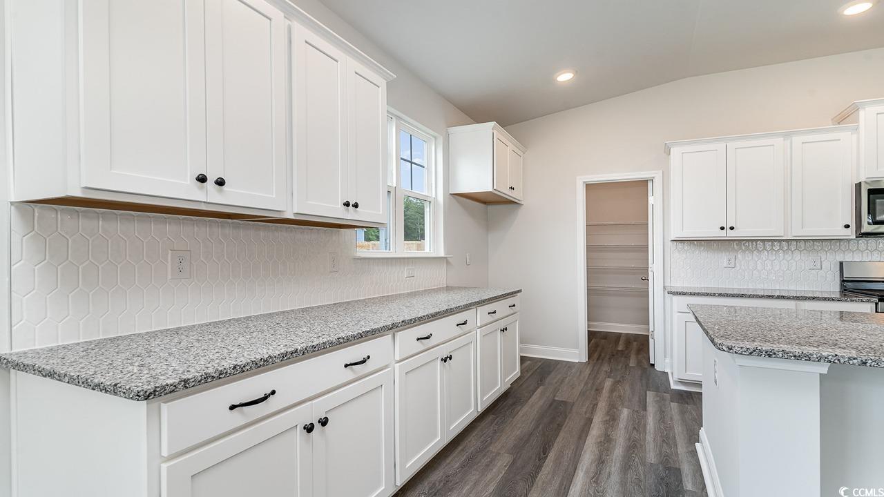 108 Fair Meadow Loris, SC 29569 - Photo 15 of 24 Kitchen with white cabinets, backsplash, dark hardwood / wood-style flooring, light stone countertops, and vaulted ceiling