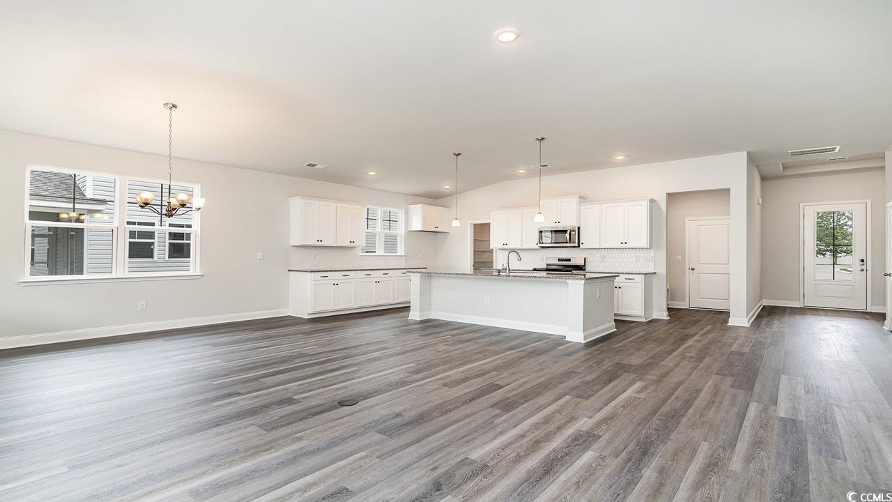 108 Fair Meadow Loris, SC 29569 - Photo 21 of 24 Kitchen with hanging light fixtures, dark hardwood / wood-style flooring, white cabinets, sink, and a center island with sink
