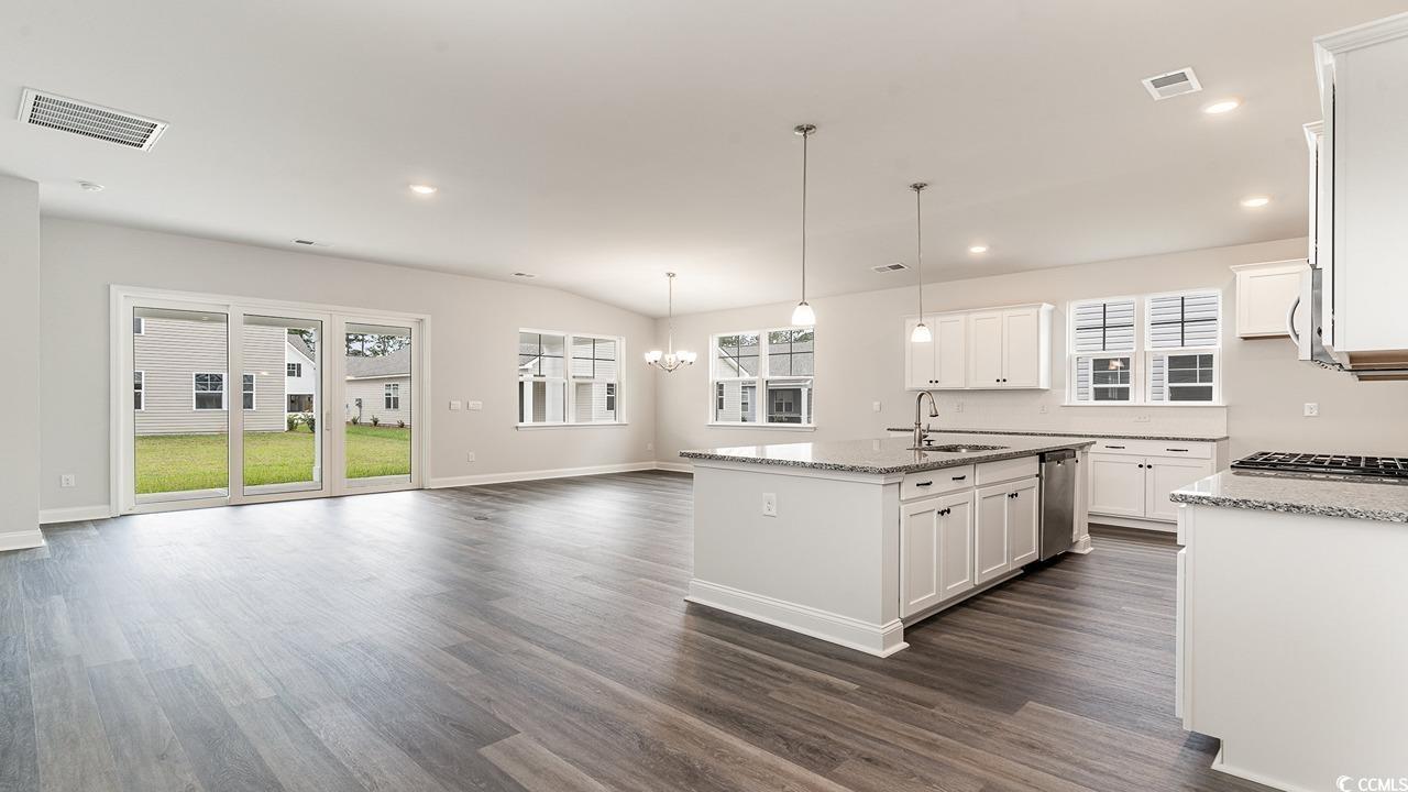 108 Fair Meadow Loris, SC 29569 - Photo 9 of 24 Kitchen with white cabinetry, dark wood-type flooring, a kitchen island with sink, light stone countertops, and sink