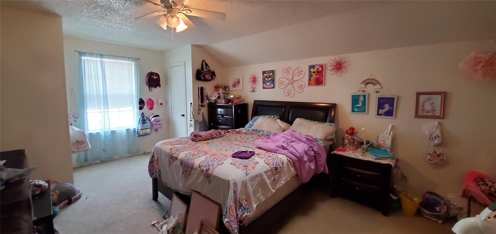 3012 North Bell Avenue Denton, TX 76209 - Photo 14 of 15 a bedroom with a bed and a chandelier