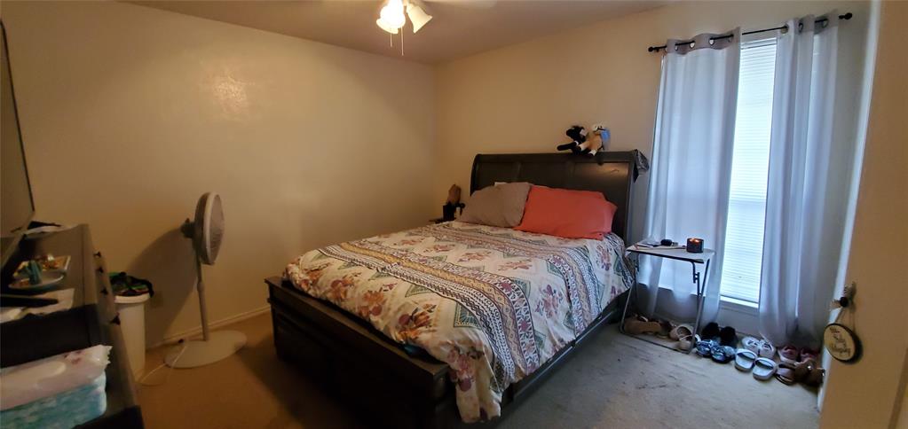 3012 North Bell Avenue Denton, TX 76209 - Photo 9 of 15 a bedroom with a bed and a chandelier