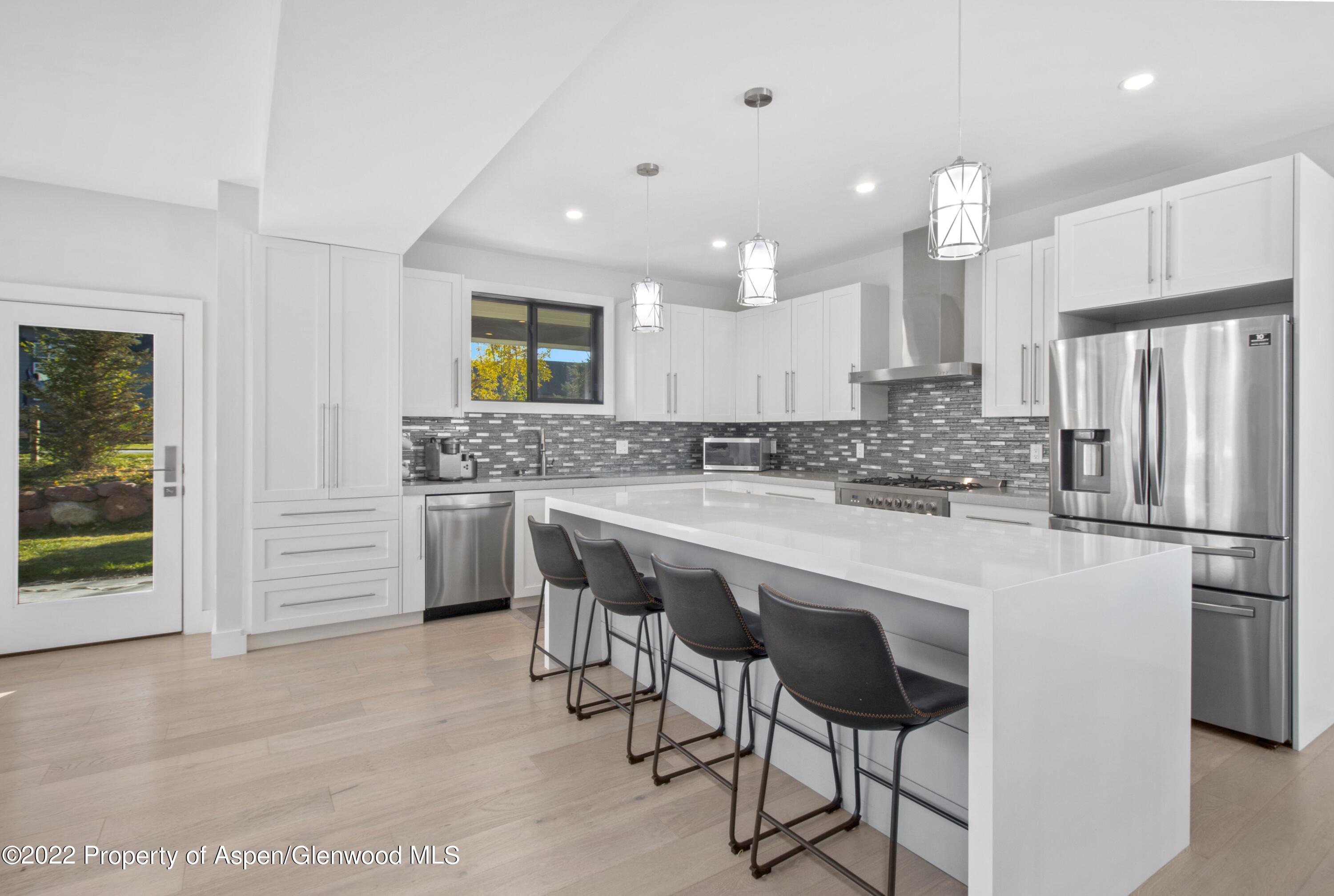 715 Eagles Nest Drive Silt, CO 81652 - Photo 4 of 19 a kitchen with stainless steel appliances granite countertop a stove a sink a refrigerator and a refrigerator with wooden floor