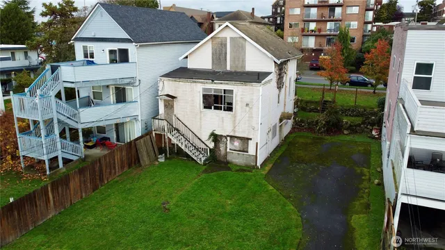 an aerial view of residential houses with yard and car parked