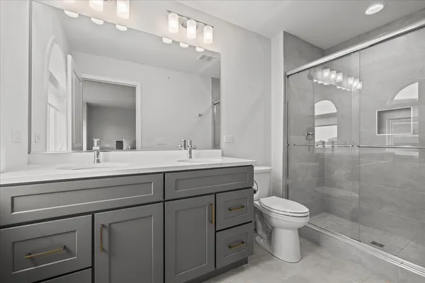 a bathroom with a sink a toilet and shower
