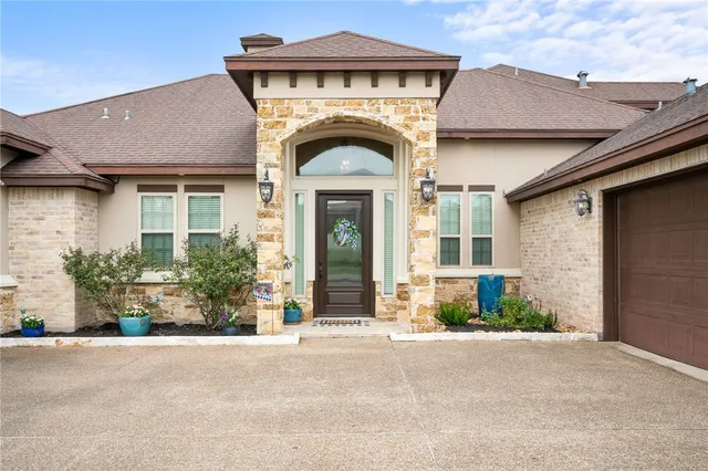 a front view of a house with a garden