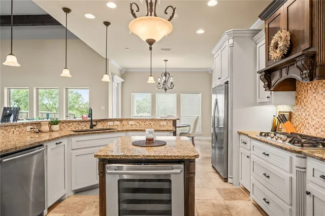 a kitchen with stainless steel appliances granite countertop a kitchen island a stove and a sink