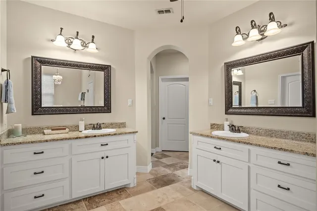 a bathroom with double vanity sinks and a mirror