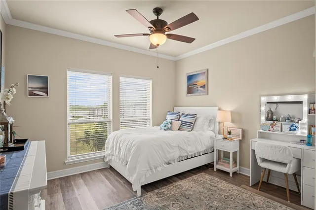 a bedroom with a bed a chandelier and a desk