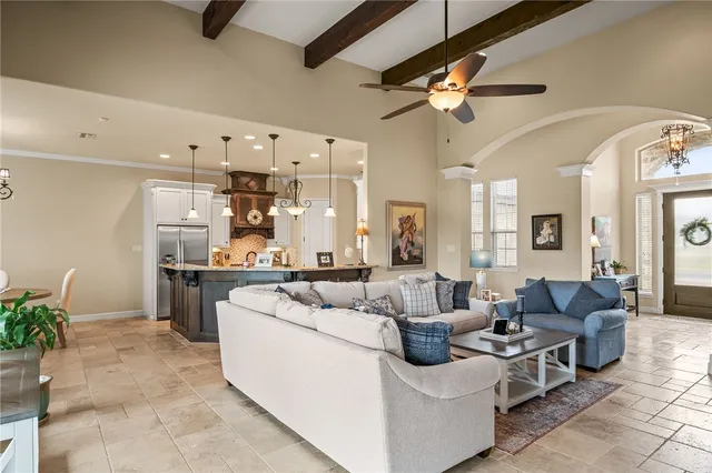 a living room with furniture kitchen view and a chandelier