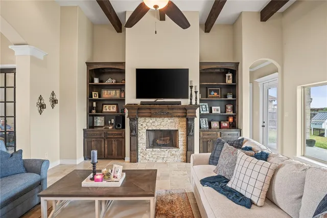 a living room with furniture a flat screen tv and a fireplace