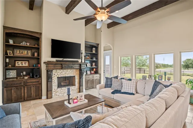 a living room with furniture a fireplace and a flat screen tv