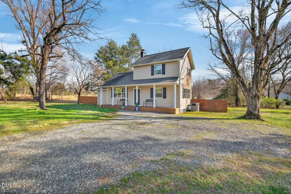 a view of a house with a big yard and large trees