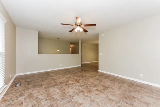 an empty room with fan and windows
