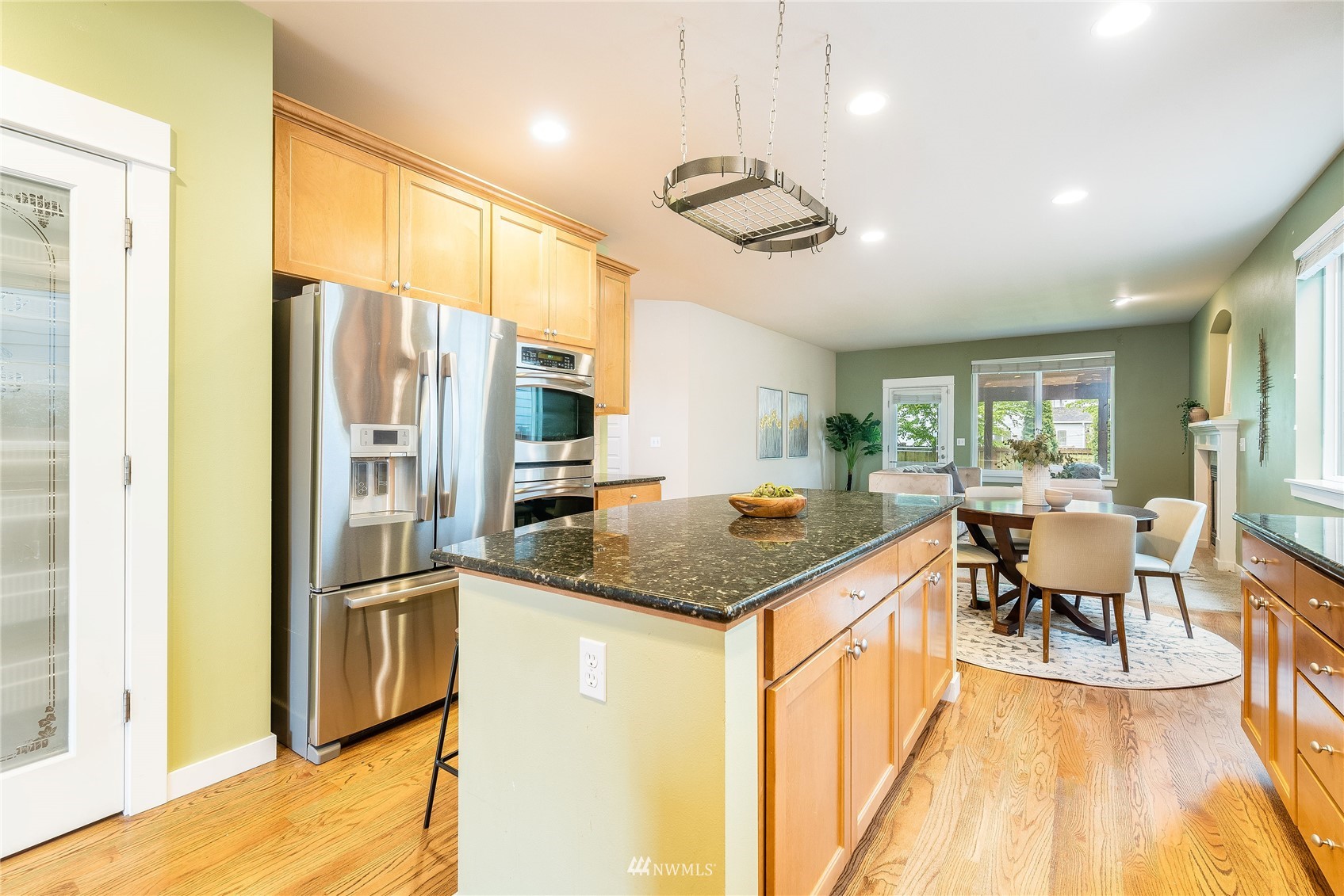 3710 222nd Place Southeast Bothell, WA 98021 - Photo 5 of 37 a kitchen with stainless steel appliances granite countertop a refrigerator a sink dishwasher a stove and a dining table with wooden floor