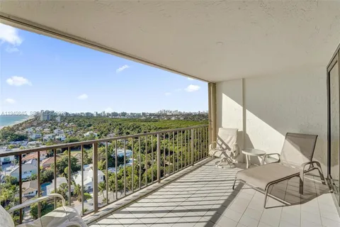 a view of a balcony with wooden floor next to a yard