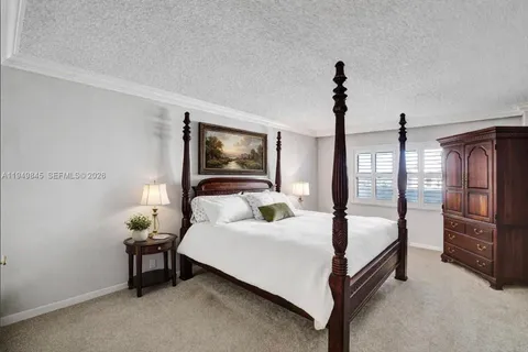 a bedroom with a bed and a lamp on the dresser