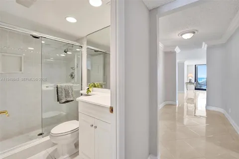 a bathroom with a granite countertop toilet a sink and a shower