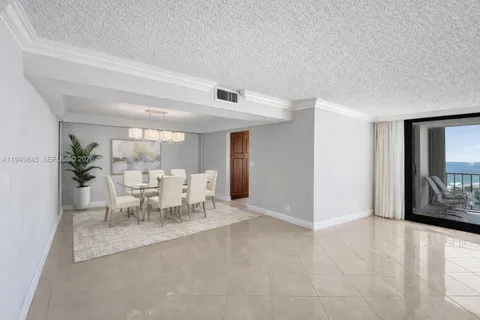 a dining room with furniture and a potted plant