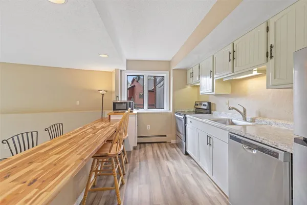 a kitchen with kitchen island granite countertop lots of counter top space and stainless steel appliances