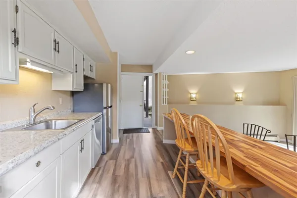 a kitchen with stainless steel appliances granite countertop a sink a stove and a wooden floors