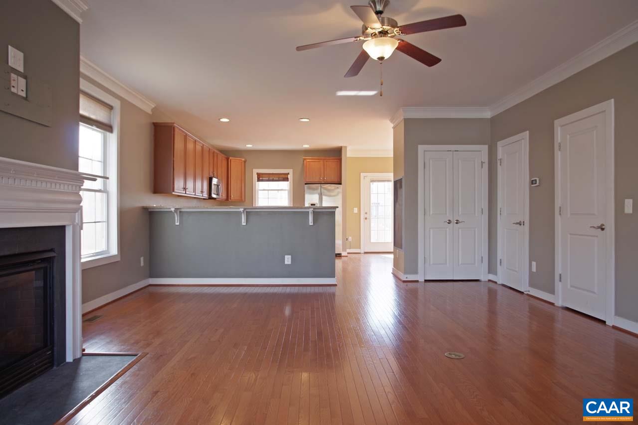 5477 Park Road Crozet, VA 22932 - Photo 7 of 47 an empty room with wooden floor a ceiling fan a fireplace and windows