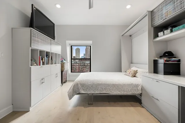 a bedroom with a large bed and a flat tv screen