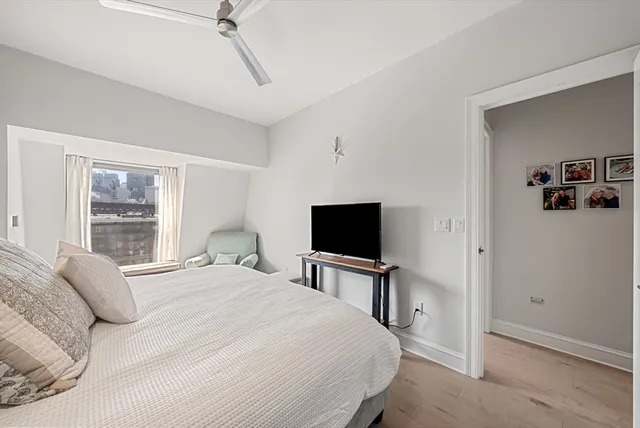 a bedroom with a bed and a dresser with bookshelf