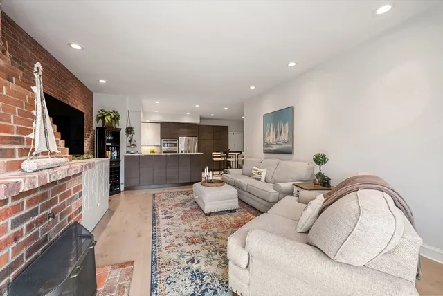 a living room with furniture a flat screen tv and kitchen view