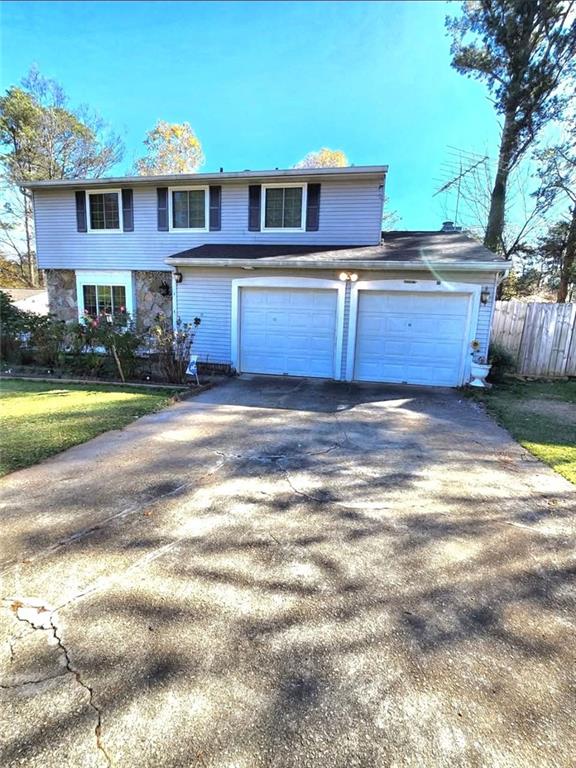 a view of a yard in front of a house with a large tree