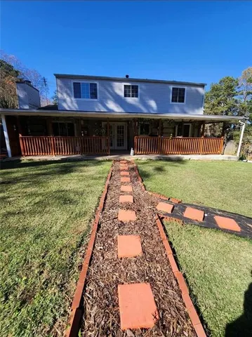 a view of a house with backyard and sitting area