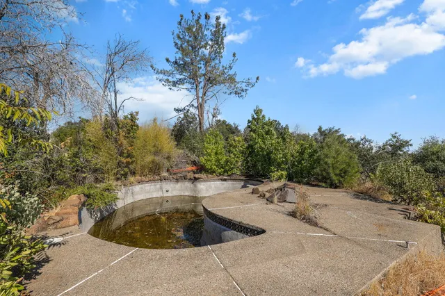 a view of a swimming pool with a yard and mountain view
