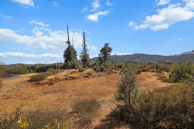 a view of a dry yard with mountains in the background