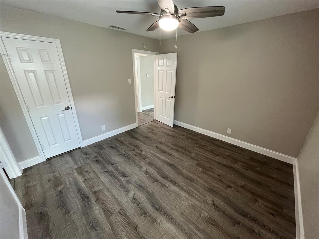 7046 Forney Road Dallas, TX 75227 - Photo 15 of 19 Interior room featuring wood-finish flooring, light gray walls, and white trim