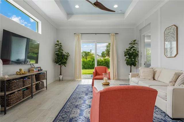 a living room with furniture a flat screen tv and a large window