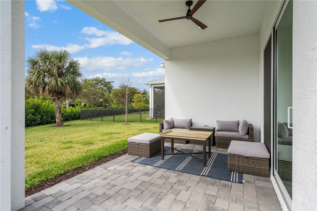 2159 Falls Manor Vero Beach, FL 32967 - Photo 35 of 36 a view of a patio with dining table and chairs with a garden