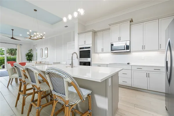 a kitchen with a table chairs sink microwave and cabinets