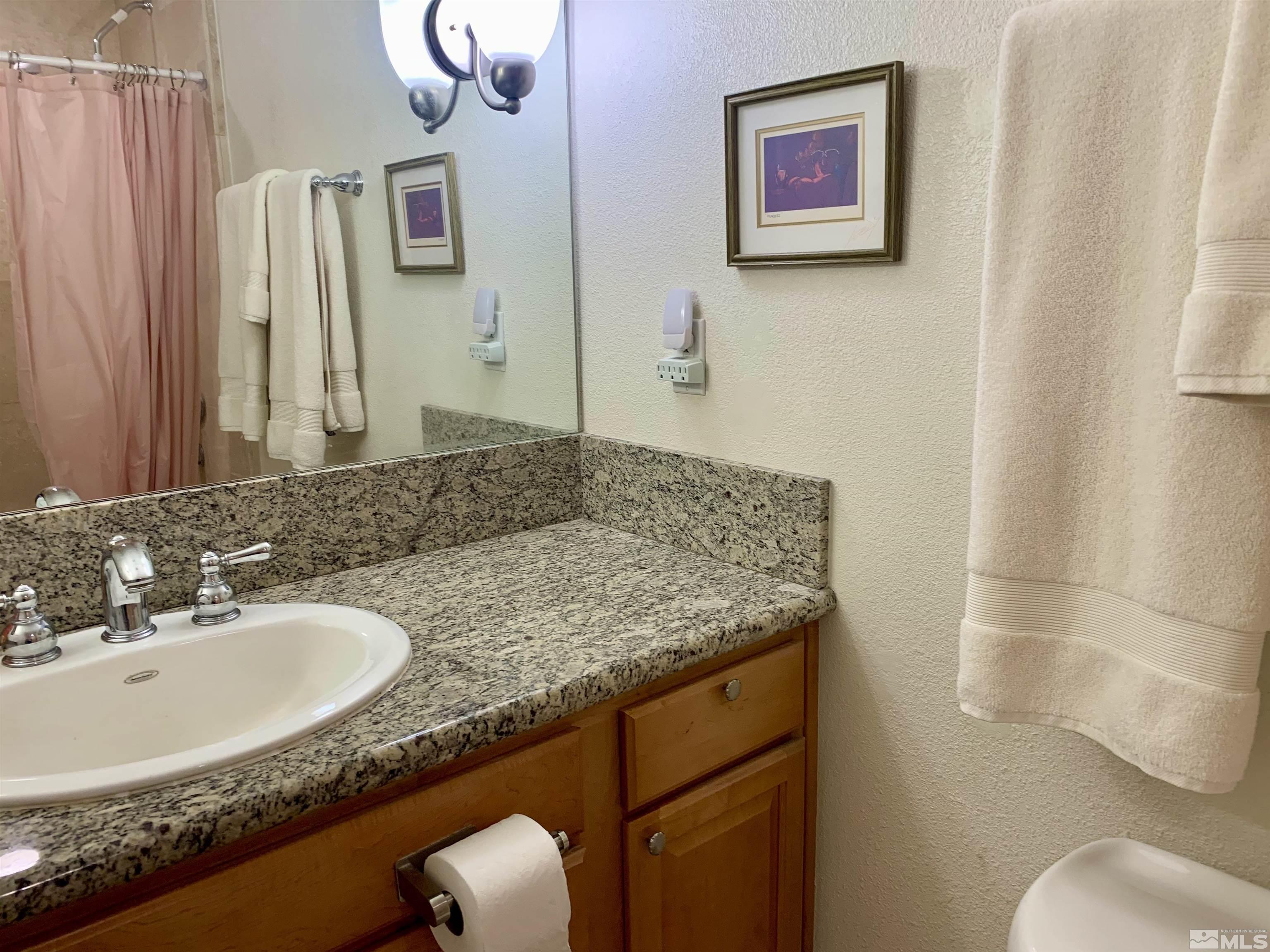 200 West 2nd Street, Unit 404 Reno, NV 89501 - Photo 17 of 30 a bathroom with a granite countertop sink and a mirror