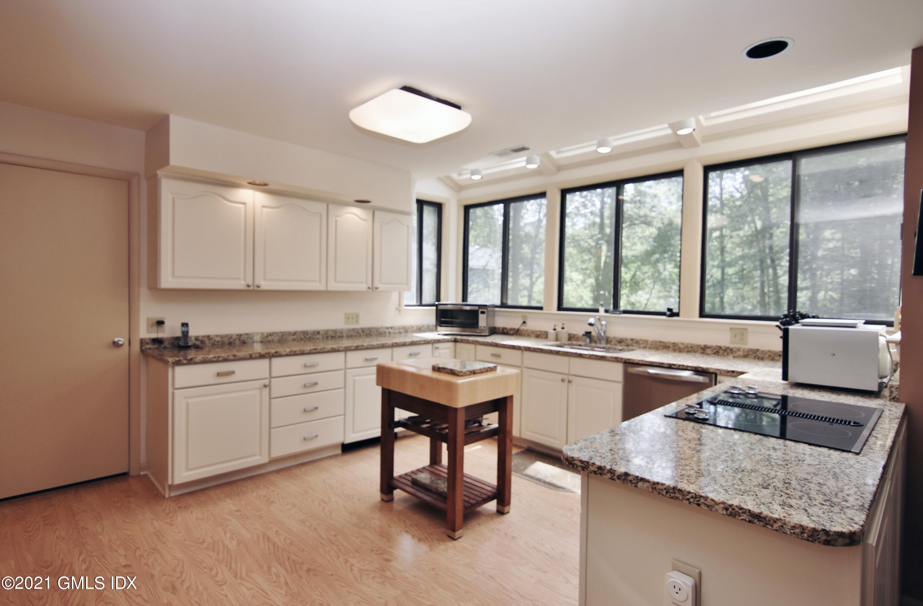 106 Gun Club Road Stamford, CT 06903 - Photo 12 of 38 a kitchen with a sink and white cabinets