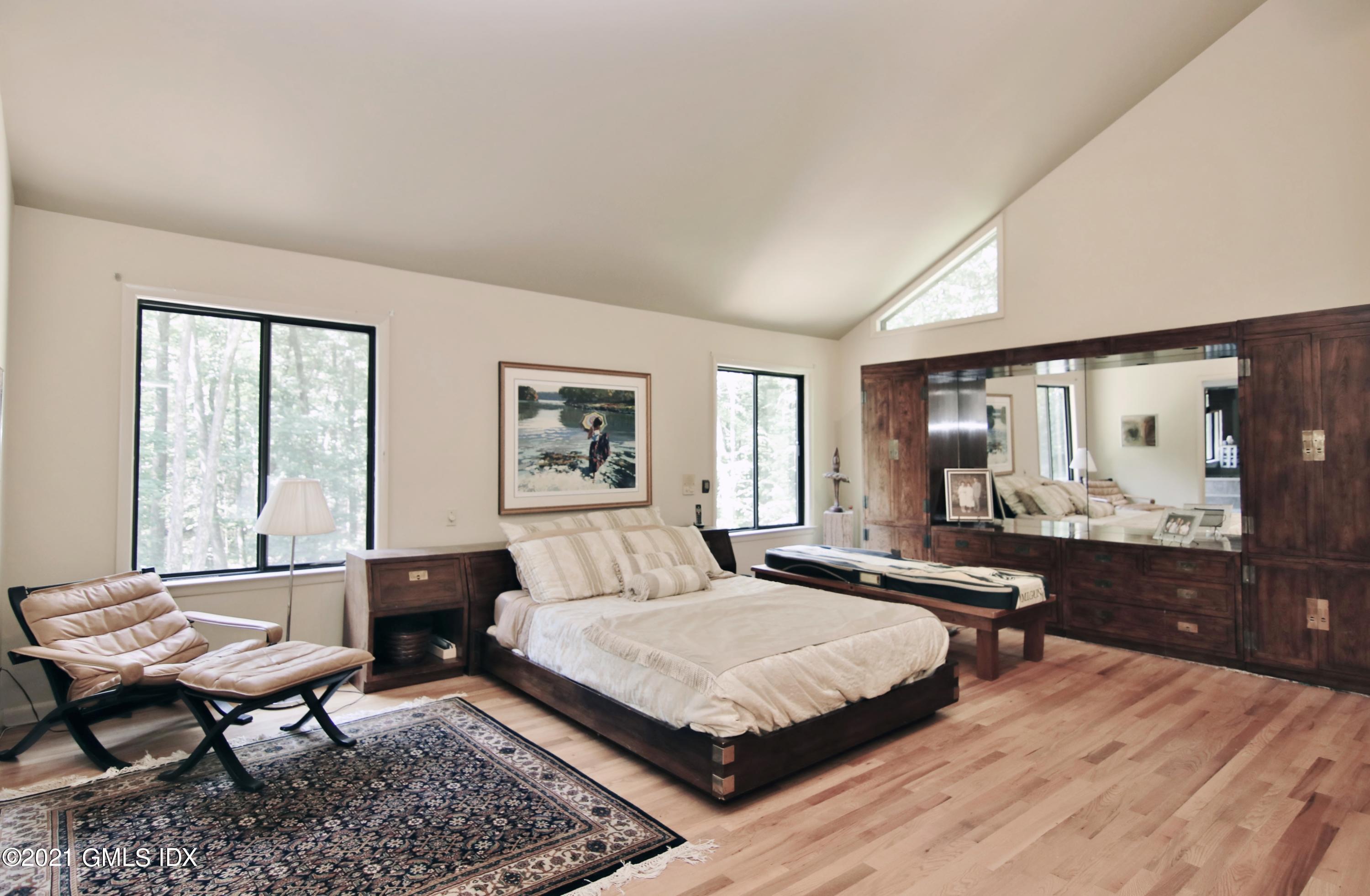 106 Gun Club Road Stamford, CT 06903 - Photo 22 of 38 a bedroom with a bed large window and couch