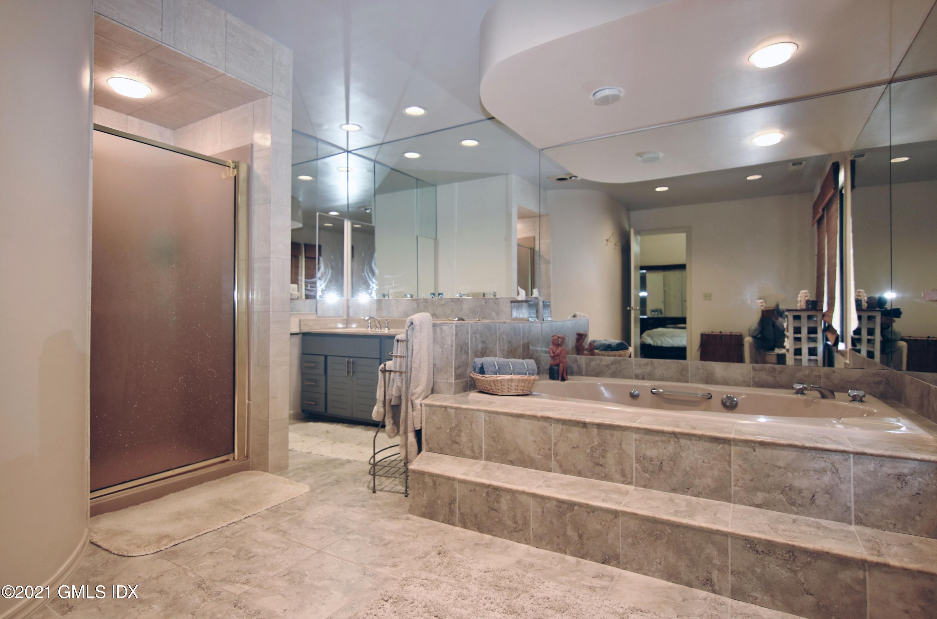 106 Gun Club Road Stamford, CT 06903 - Photo 23 of 38 a large bathroom with a large mirror vanity and shower