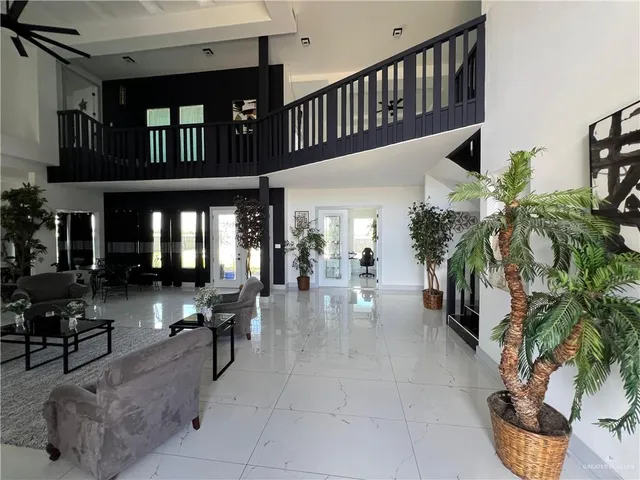 a gym area with lots of furniture and potted plants